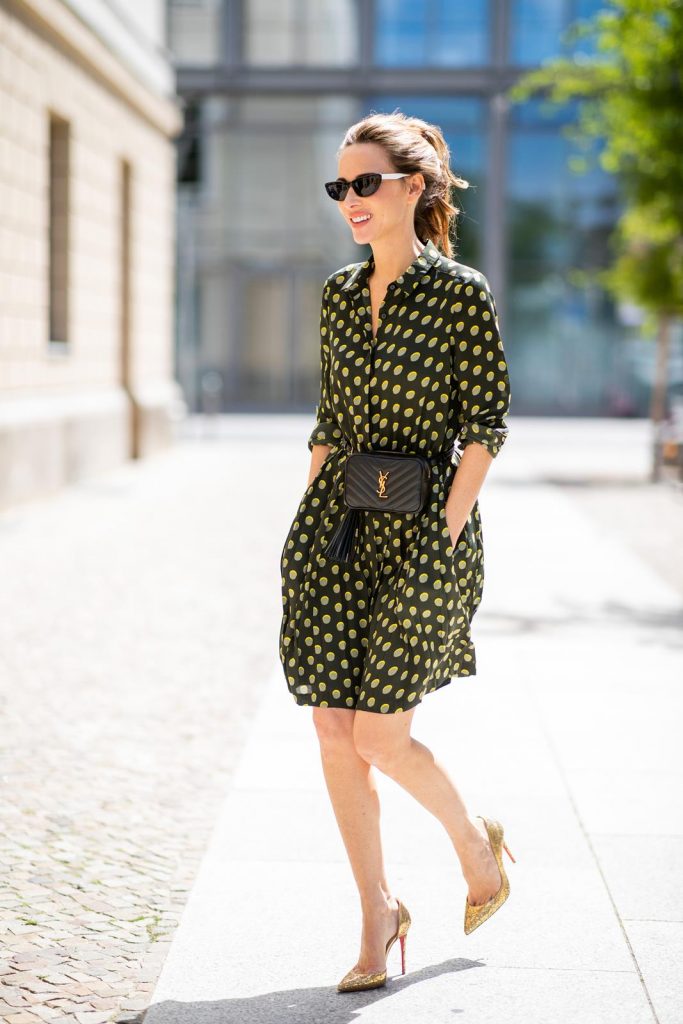 Steffen Schraut, Saint Laurent, Christian Louboutin, State Optical Co. Alexandra Lapp is seen in a Waist Belt Bag Look wearing a knee length dark green dress with green and yellow dots from Steffen Schraut, the Lou Belt Bag in black by Saint Laurent, the golden Iriza glitter pumps by Christian Louboutin and two tone sunglasses from State x Cotw in black white on July 13, 2018 in Berlin, Germany.