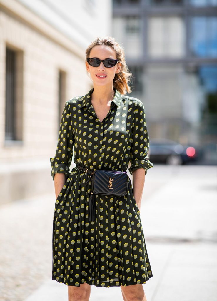 Steffen Schraut, Saint Laurent, Christian Louboutin, State Optical Co. Alexandra Lapp is seen in a Waist Belt Bag Look wearing a knee length dark green dress with green and yellow dots from Steffen Schraut, the Lou Belt Bag in black by Saint Laurent, the golden Iriza glitter pumps by Christian Louboutin and two tone sunglasses from State x Cotw in black white on July 13, 2018 in Berlin, Germany.