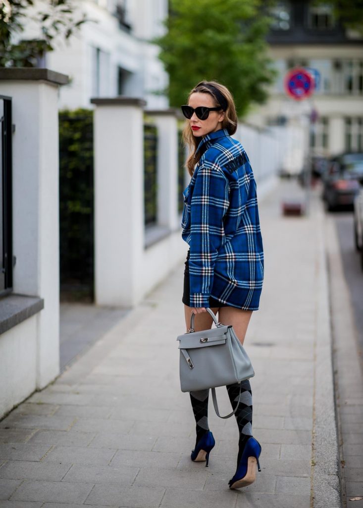 Alexandra Lapp in a Burlington Socks | Hairband Style wearing a blue embroidered check shirt by Gucci, a black wool skirt by Isabel Marant, blue Hangisi satin Manolo Blahnik pumps, grey black knee-high Burlington socks, a grey Hermes Birkin bag, a vintage black Hermes belt and black Celine sunglasses on May 3, 2018 in Duesseldorf, Germany.