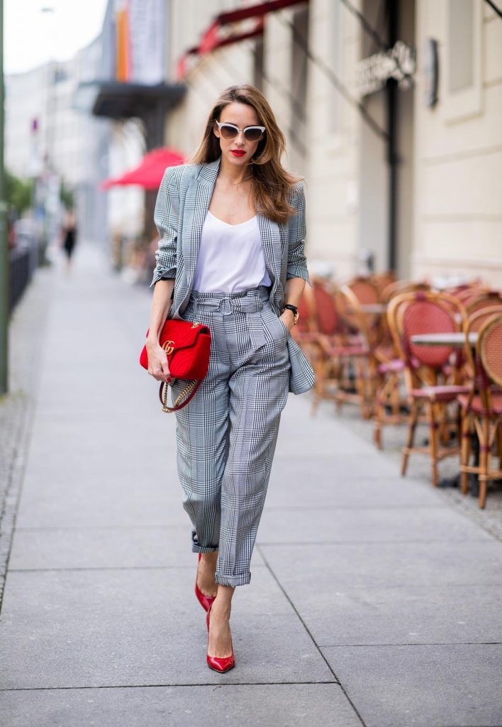 Alexandra Lapp for Big Dream | Riani wearing a checkered suit combination in black and white with a long blazer and high waist pants with an integrated belt both from Riani, a white silk top from Jadicted, red lacquer Gianvito Rossi pumps, red velvet GG Marmont Gucci handbag, vintage Gucci sunglasses and an IWC watch during the Berlin Fashion Week July 2018 on July 6, 2018 in Berlin, Germany.
