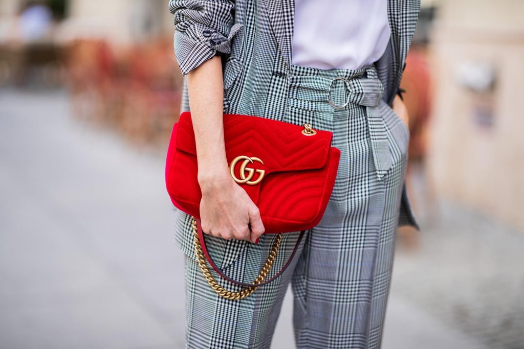 Alexandra Lapp for Big Dream | Riani wearing a checkered suit combination in black and white with a long blazer and high waist pants with an integrated belt both from Riani, a white silk top from Jadicted, red lacquer Gianvito Rossi pumps, red velvet GG Marmont Gucci handbag, vintage Gucci sunglasses and an IWC watch during the Berlin Fashion Week July 2018 on July 6, 2018 in Berlin, Germany.