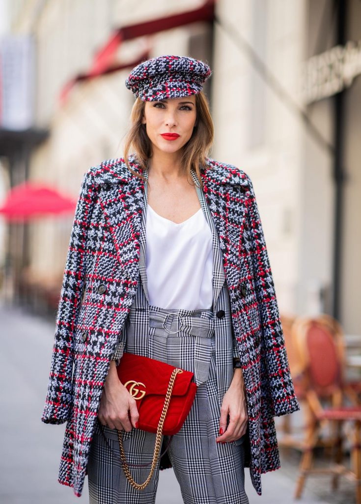 Alexandra Lapp for Big Dream | Riani wearing a checkered suit combination in black and white with a long blazer and high waist pants with an integrated belt both from Riani, a white silk top from Jadicted, red lacquer Gianvito Rossi pumps, red velvet GG Marmont Gucci handbag, vintage Gucci sunglasses and an IWC watch during the Berlin Fashion Week July 2018 on July 6, 2018 in Berlin, Germany.
