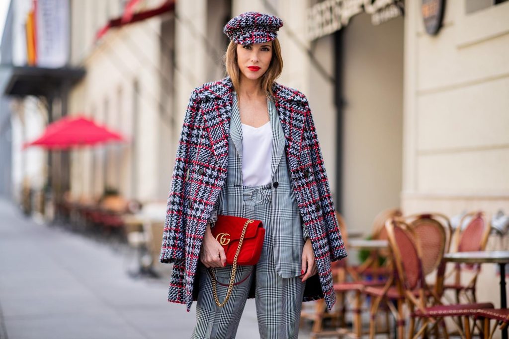 Alexandra Lapp for Big Dream | Riani wearing a checkered suit combination in black and white with a long blazer and high waist pants with an integrated belt both from Riani, a white silk top from Jadicted, red lacquer Gianvito Rossi pumps, red velvet GG Marmont Gucci handbag, vintage Gucci sunglasses and an IWC watch during the Berlin Fashion Week July 2018 on July 6, 2018 in Berlin, Germany.