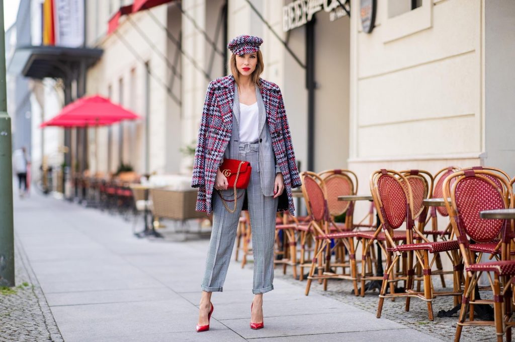 Alexandra Lapp for Big Dream | Riani wearing a checkered suit combination in black and white with a long blazer and high waist pants with an integrated belt both from Riani, a white silk top from Jadicted, red lacquer Gianvito Rossi pumps, red velvet GG Marmont Gucci handbag, vintage Gucci sunglasses and an IWC watch during the Berlin Fashion Week July 2018 on July 6, 2018 in Berlin, Germany.