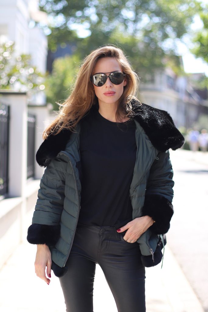 Airfield, SET, James Perse, Saint Laurent, Hermès, Céline Model and Blogger Alexandra Lapp in a Faux Fur Jacket Look wearing a black down jacket with faux fur by Airfield, black leather pants by SET, black T-Shirt by James Perse, dark green leather overknee boots by Saint Laurent, black Kelly bag by Hermès and black Audrey sunglasses from Céline.