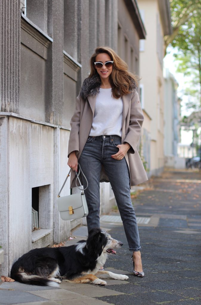 Model and Blogger Alexandra Lapp wearing a Céline Box Bag Look with a wool coat with fur collar in taupe, a light white wool sweater by Zara, grey Levi’s jeans, camouflage Gianvito Rossi pumps, vintage Gucci sunglasses and a light grey Céline box bag in Düsseldorf, Germany.