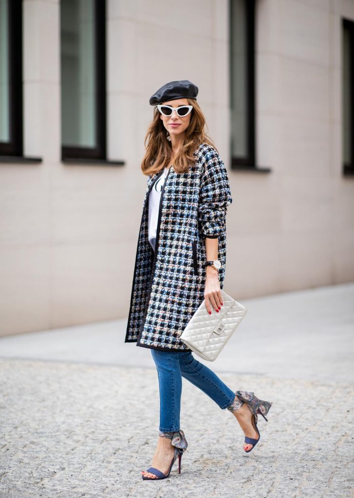 Alexandra Lapp wearing an oversized college jacket look with an oversized checkered college jacket from Steffen Schraut, stirrup denim pants from Steffen Schraut, a white V-neck t-shirt saying Vogue on the front from Your&Self, High Heel Sandals Sandale Du Desert in denim blue with a printed satin bow from Christian Louboutin, a silver Chanel handbag, white cat-eye sunglasses from YSL - Saint Laurent and Eugenia Kim leather basque Cher Barett on July 13, 2018 in Berlin, Germany.