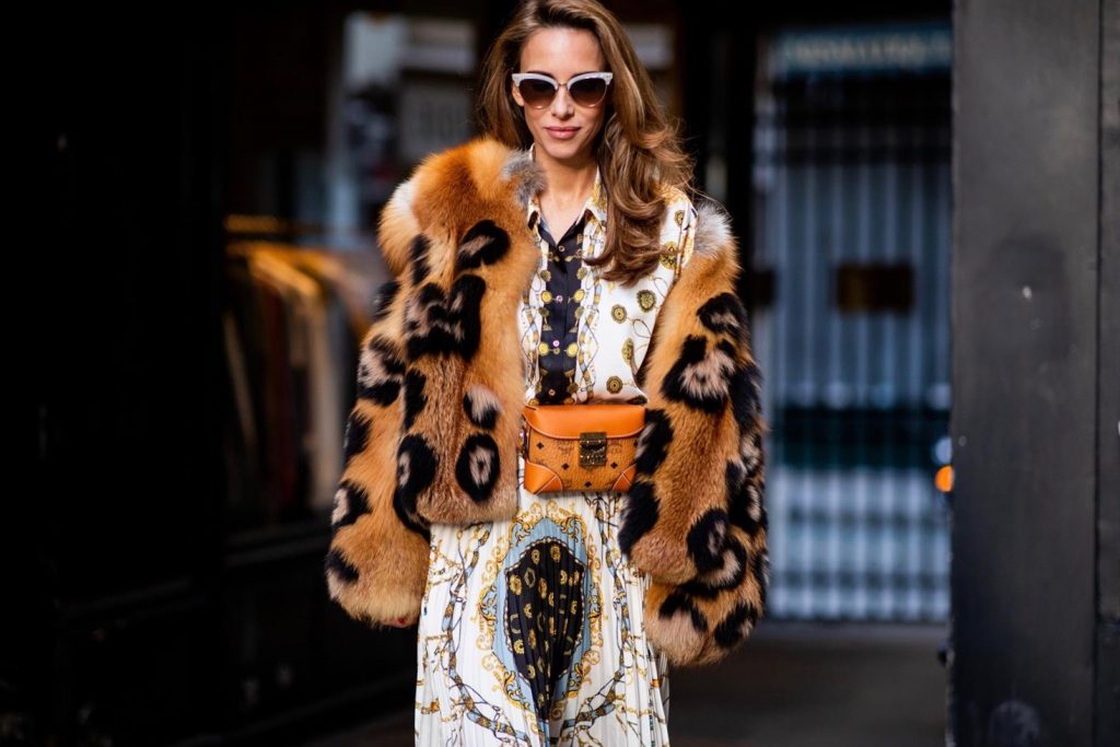 Zara, Yves Salomon, MCM, Christian Louboutin, Gucci Alexandra Lapp in a Pattern Mix wearing a pleating chain patchwork print skirt and a matching shirt from Zara, a short fur jacket from Yves Salomon with an animal print, Metrisandal open-toe sandals from Christian Louboutin with tape-style straps, the Soft Berlin Belt Bag in Visetos by MCM in cognac and the Gucci cat-eye radiant ivory sunglasses during Paris Fashion Week Womenswear Spring/Summer 2019 on September 24, 2018 in Paris, France.