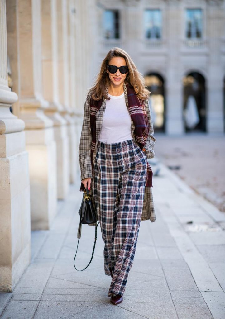 Alexandra Lapp in a Layered Look wearing a plaid oversized coat from SET fashion, a white T-Shirt from Vince, a Glenchek style scarf in dark red tones, wide plaid pants with a long leg in blue and brown tones from Tory Burch, boots in bordeaux from Gianvito Rossi and black Audrey sunglasses from Celine during Paris Fashion Week Womenswear Spring/Summer 2019 on September 27, 2018 in Paris, France.