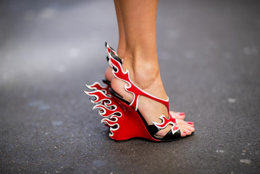 Alexandra Lapp in a Prada Flame Sandals / Graphic Pattern Look wearing a Cindy Blazer with graphic pattern by Airfield, a red leather pencil skirt by American Retro, red flame wedge sandal heels from Prada and a vintage Dior saddle bag in cognac, Gucci cat-eye radiant ivory sunglasses and brown cognac soft leather belt by Prada is seen during Paris Fashion Week Womenswear Spring/Summer 2019 on September 25, 2018 in Paris, France.