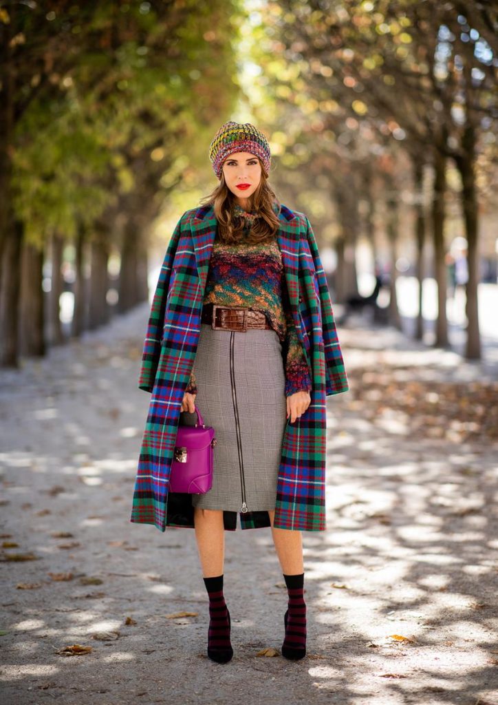 Alexandra Lapp in a Mixed Prints Look wearing a long multicolored plaid coat and a wool turtleneck multicolored sweater from Ouì, a black and white plaid slim cut skirt with a zipper up front from Ouì, a brown waist belt from Max Mara, black suede high heels from Christian Louboutin, the Soft Berlin Crossbody Bag in Viva Lilac from MCM, a multicolored wool hat from Missoni, purple black striped socks by H&M and the black Audrey sunglasses from Celine during Paris Fashion Week Womenswear Spring/Summer 2019 on September 25, 2018 in Paris, France.