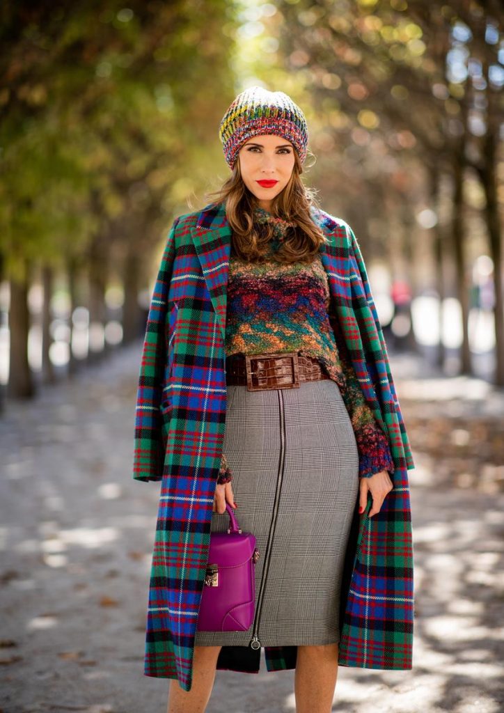 Alexandra Lapp in a Mixed Prints Look wearing a long multicolored plaid coat and a wool turtleneck multicolored sweater from Ouì, a black and white plaid slim cut skirt with a zipper up front from Ouì, a brown waist belt from Max Mara, black suede high heels from Christian Louboutin, the Soft Berlin Crossbody Bag in Viva Lilac from MCM, a multicolored wool hat from Missoni, purple black striped socks by H&M and the black Audrey sunglasses from Celine during Paris Fashion Week Womenswear Spring/Summer 2019 on September 25, 2018 in Paris, France.