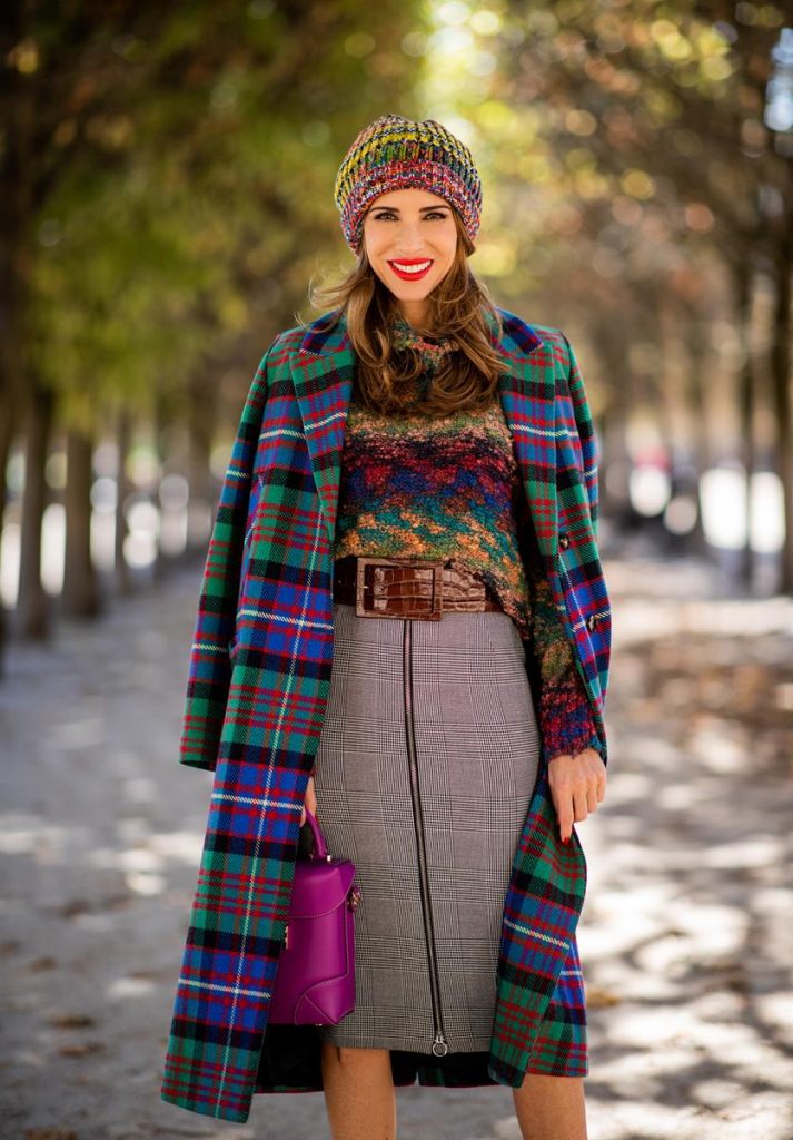 Alexandra Lapp in a Mixed Prints Look wearing a long multicolored plaid coat and a wool turtleneck multicolored sweater from Ouì, a black and white plaid slim cut skirt with a zipper up front from Ouì, a brown waist belt from Max Mara, black suede high heels from Christian Louboutin, the Soft Berlin Crossbody Bag in Viva Lilac from MCM, a multicolored wool hat from Missoni, purple black striped socks by H&M and the black Audrey sunglasses from Celine during Paris Fashion Week Womenswear Spring/Summer 2019 on September 25, 2018 in Paris, France.