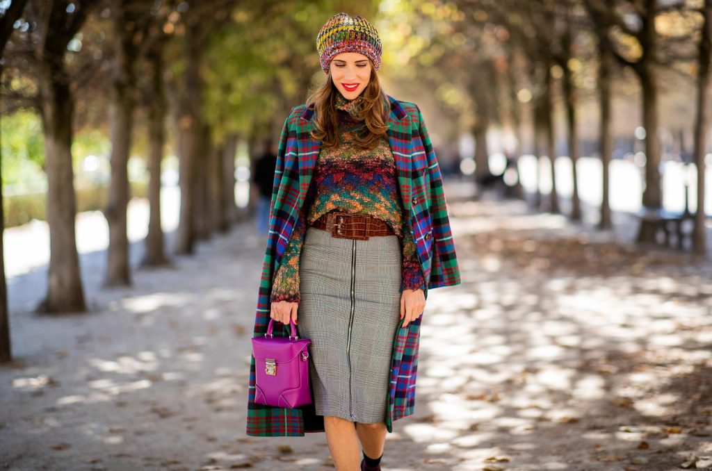 Alexandra Lapp in a Mixed Prints Look wearing a long multicolored plaid coat and a wool turtleneck multicolored sweater from Ouì, a black and white plaid slim cut skirt with a zipper up front from Ouì, a brown waist belt from Max Mara, black suede high heels from Christian Louboutin, the Soft Berlin Crossbody Bag in Viva Lilac from MCM, a multicolored wool hat from Missoni, purple black striped socks by H&M and the black Audrey sunglasses from Celine during Paris Fashion Week Womenswear Spring/Summer 2019 on September 25, 2018 in Paris, France.