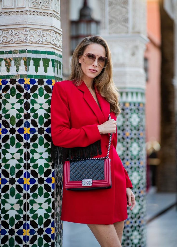 Alexandra Lapp in a red Blazer dress look wearing a red blazer dress with fringes at both arms from Pearl and Rubies, black Cowboy boots with a silver tip from Isabel Marant, red and black boy bag from Chanel and oversized sunglasses from Chloe on November 25, 2018 in Marrakech, Morocco. (Photo by Christian Vierig/Getty Images)