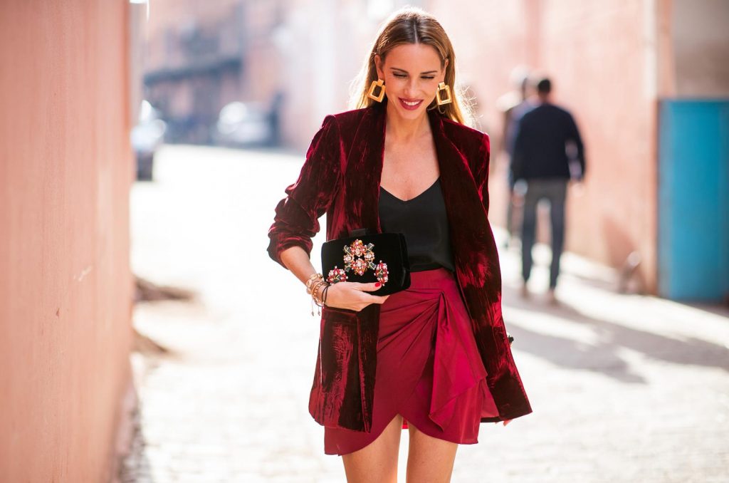 Caroline Constas, Jadicted, Cult Gaia, Alice + Olivia, Roger Vivier, Zara Alexandra Lapp in a wrap skirt look wearing a loose fit crushed velvet red blazer from Alice + Olivia, a black top from Jadicted, a satin red mini skirt with a rap-effect from Caroline Constas, a black velvet handbag with sparkling stones and pearls from Roger Vivier, black woven Sienna sandals from Cult Gaia, gold earrings from Zara on November 26, 2018 in Marrakech, Morocco. (Photo by Christian Vierig/Getty Images)