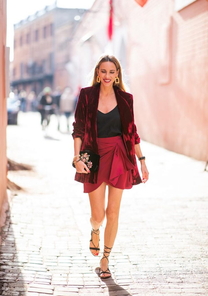 Caroline Constas, Jadicted, Cult Gaia, Alice + Olivia, Roger Vivier, Zara Alexandra Lapp in a wrap skirt look wearing a loose fit crushed velvet red blazer from Alice + Olivia, a black top from Jadicted, a satin red mini skirt with a rap-effect from Caroline Constas, a black velvet handbag with sparkling stones and pearls from Roger Vivier, black woven Sienna sandals from Cult Gaia, gold earrings from Zara on November 26, 2018 in Marrakech, Morocco. (Photo by Christian Vierig/Getty Images)