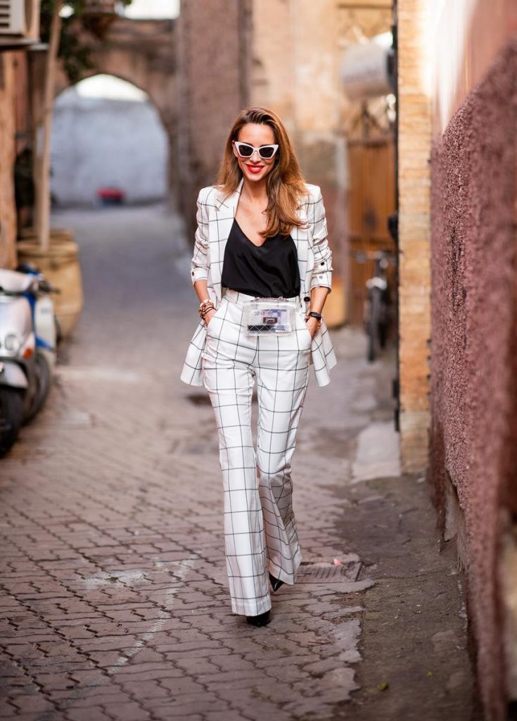 Alexandra Lapp in a ladysuit look, wearing the Pierre double-breasted checkered suit combination in black and white from Rebecca Vallance with matching high rise pants with a flared hem, a black top from Jadicted, black lacquer high heels with sparkling heels from Philipp Plein, a golden Portugieser Chronograph from IWC and a transparent waisted belt bag and white Saint Laurent New Wave 213 Lily sunglasses on November 25, 2018 in Marrakech, Morocco. (Photo by Christian Vierig/Getty Images)