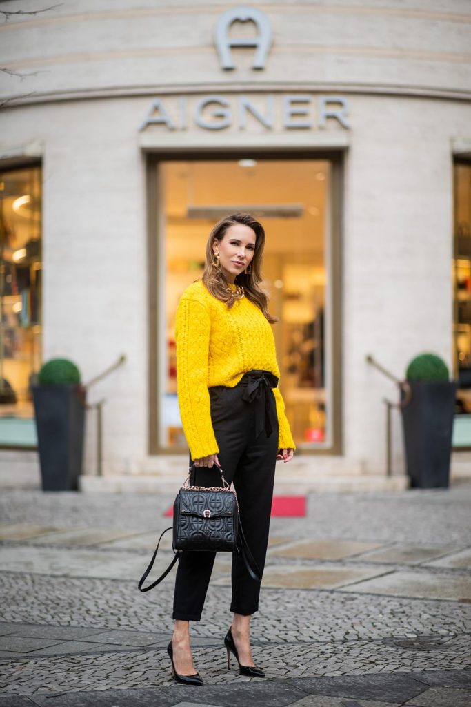 Alexandra Lapp in a Diadora Backpack look, wearing a cropped yellow cable knit sweater from R13 with paperbag pants from H&M, Gianvito Rossi patent leather pumps, Zara earrings and a H&M statement necklace and Aigner Diadora M backpack in during the Berlin Fashion Week Autumn/Winter 2019 on January 17, 2019 in Berlin, Germany. (Photo by Christian Vierig/Getty Images)