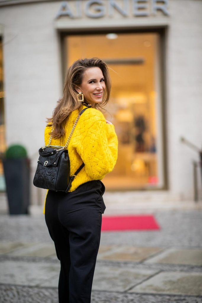 Alexandra Lapp in a Diadora Backpack look, wearing a cropped yellow cable knit sweater from R13 with paperbag pants from H&M, Gianvito Rossi patent leather pumps, Zara earrings and a H&M statement necklace and Aigner Diadora M backpack in during the Berlin Fashion Week Autumn/Winter 2019 on January 17, 2019 in Berlin, Germany. (Photo by Christian Vierig/Getty Images)