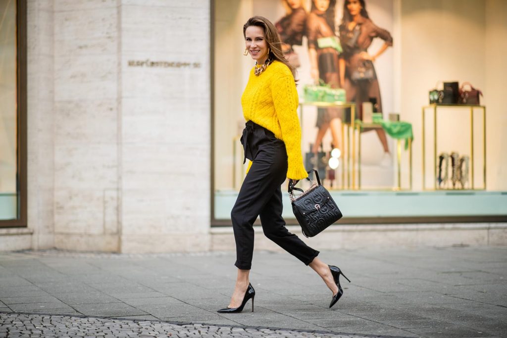 Alexandra Lapp in a Diadora Backpack look, wearing a cropped yellow cable knit sweater from R13 with paperbag pants from H&M, Gianvito Rossi patent leather pumps, Zara earrings and a H&M statement necklace and Aigner Diadora M backpack in during the Berlin Fashion Week Autumn/Winter 2019 on January 17, 2019 in Berlin, Germany. (Photo by Christian Vierig/Getty Images)