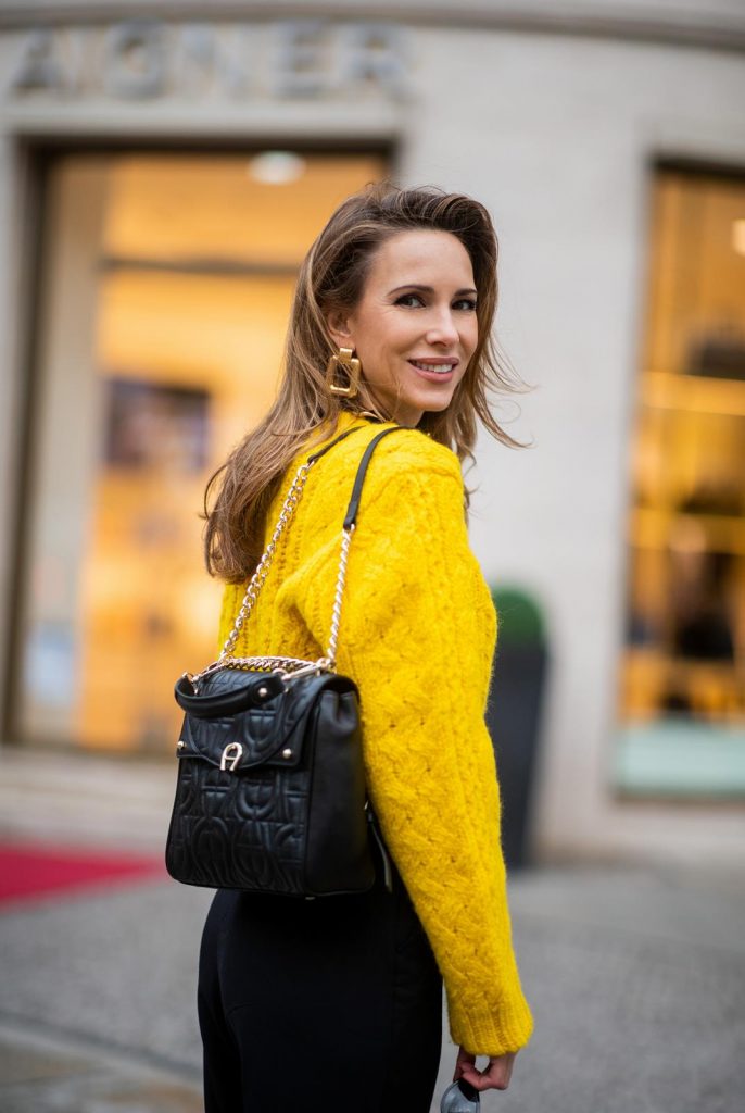 Alexandra Lapp in a Diadora Backpack look, wearing a cropped yellow cable knit sweater from R13 with paperbag pants from H&M, Gianvito Rossi patent leather pumps, Zara earrings and a H&M statement necklace and Aigner Diadora M backpack in during the Berlin Fashion Week Autumn/Winter 2019 on January 17, 2019 in Berlin, Germany. (Photo by Christian Vierig/Getty Images)