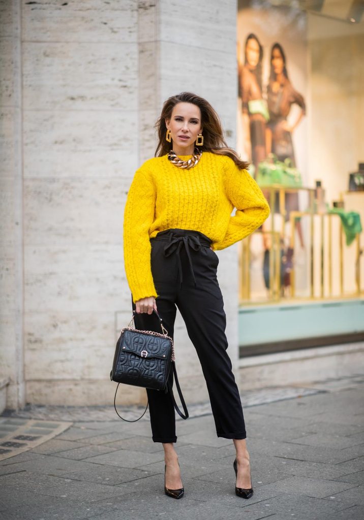 Alexandra Lapp in a Diadora Backpack look, wearing a cropped yellow cable knit sweater from R13 with paperbag pants from H&M, Gianvito Rossi patent leather pumps, Zara earrings and a H&M statement necklace and Aigner Diadora M backpack in during the Berlin Fashion Week Autumn/Winter 2019 on January 17, 2019 in Berlin, Germany. (Photo by Christian Vierig/Getty Images)