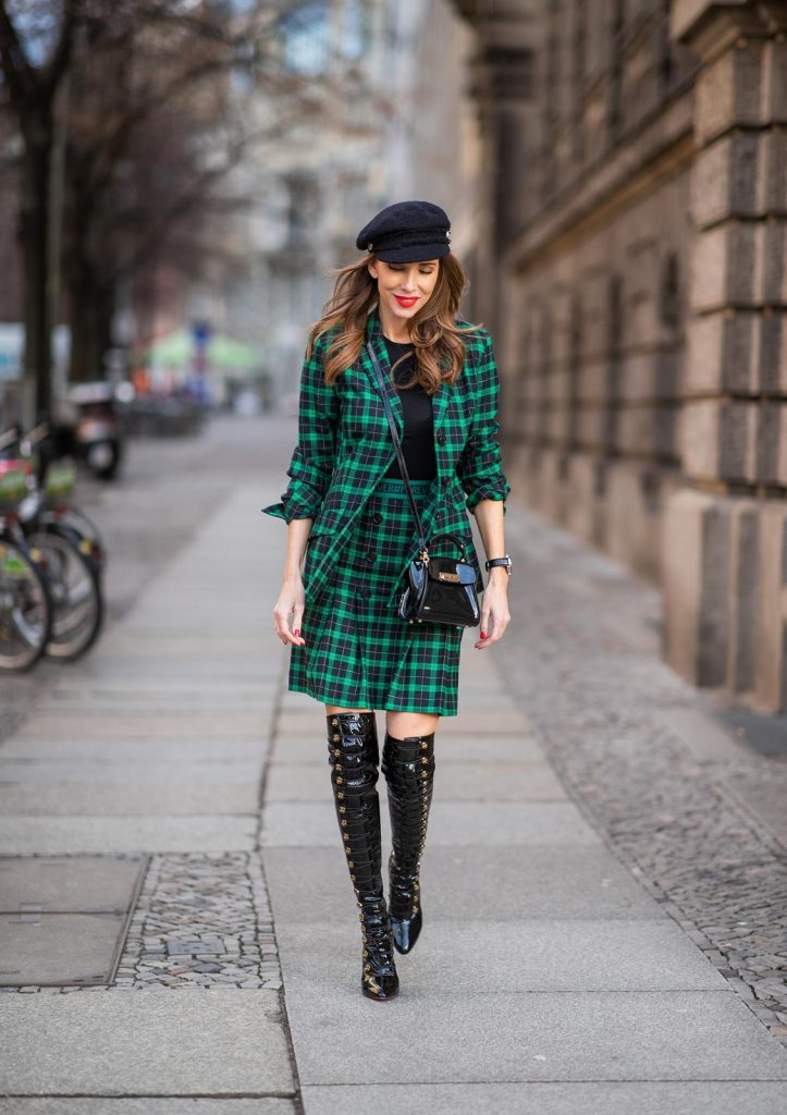 Alexandra Lapp in a checkered suit look, wearing a feminine green checkered Riani blazer with a matching pleated skirt, styled with a Vince knitted T-shirt, a black Chanel tweed baker boy cap, patent leather Louise over-the-knee boots from Christian Louboutin, and a ZAC Zac Posen patent Mini 'Eartha Iconic‘ bag during the Berlin Fashion Week Autumn/Winter 2019 on January 18, 2019 in Berlin, Germany. (Photo by Christian Vierig/Getty Images)