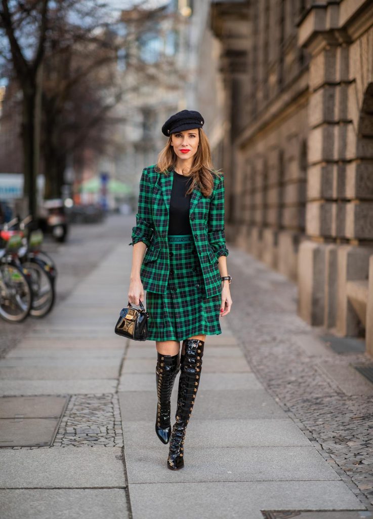 Alexandra Lapp in a checkered suit look, wearing a feminine green checkered Riani blazer with a matching pleated skirt, styled with a Vince knitted T-shirt, a black Chanel tweed baker boy cap, patent leather Louise over-the-knee boots from Christian Louboutin, and a ZAC Zac Posen patent Mini 'Eartha Iconic‘ bag during the Berlin Fashion Week Autumn/Winter 2019 on January 18, 2019 in Berlin, Germany. (Photo by Christian Vierig/Getty Images)