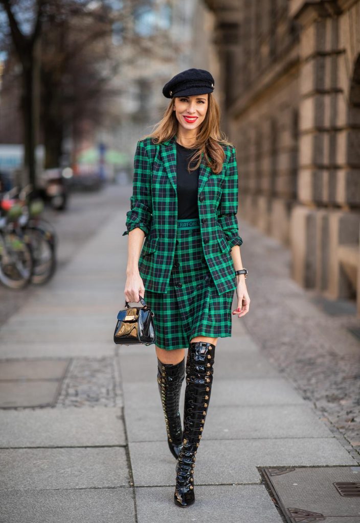 Alexandra Lapp in a checkered suit look, wearing a feminine green checkered Riani blazer with a matching pleated skirt, styled with a Vince knitted T-shirt, a black Chanel tweed baker boy cap, patent leather Louise over-the-knee boots from Christian Louboutin, and a ZAC Zac Posen patent Mini 'Eartha Iconic‘ bag during the Berlin Fashion Week Autumn/Winter 2019 on January 18, 2019 in Berlin, Germany. (Photo by Christian Vierig/Getty Images)