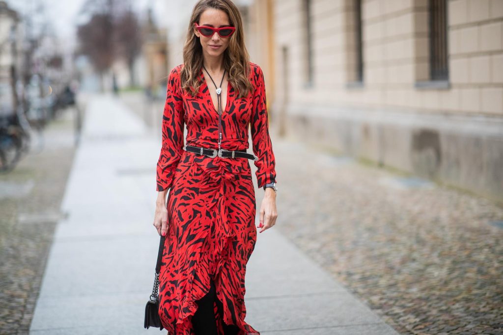 Alexandra Lapp in a Red Animal Print Look, wearing the long Adriana animal print dress from Rixo, a black and white wool coat from Ganni, the Isabel Marant Lamsy cowboy boots, a black boy bag from Chanel, a silver buckled H&M cowboy belt, a western cowboy necklace and red cat-eyed sunglasses by Celine during the Berlin Fashion Week Autumn/Winter 2019 on January 15, 2019 in Berlin, Germany. (Photo by Christian Vierig/Getty Images)