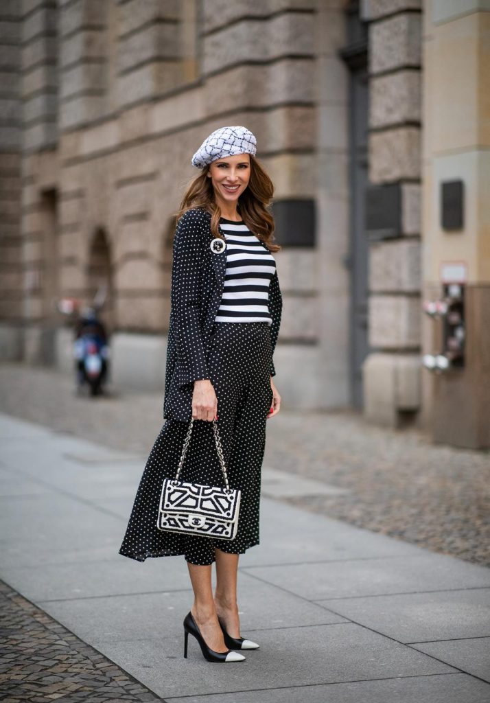 Chanel, Steffen Schraut, Manolo Blahnik Alexandra Lapp in a tweed beret dot suit look, wearing a long black blazer with dots and matching culotte pants, black and white striped sweater with a yellow detail from Steffen Schraut, a black and white tweed beret from the Chanel La Pausa collection, a black and white 2.55 flap bag from Chanel during the Berlin Fashion Week Autumn/Winter 2019 on January 16, 2019 in Berlin, Germany. (Photo by Christian Vierig/Getty Images)