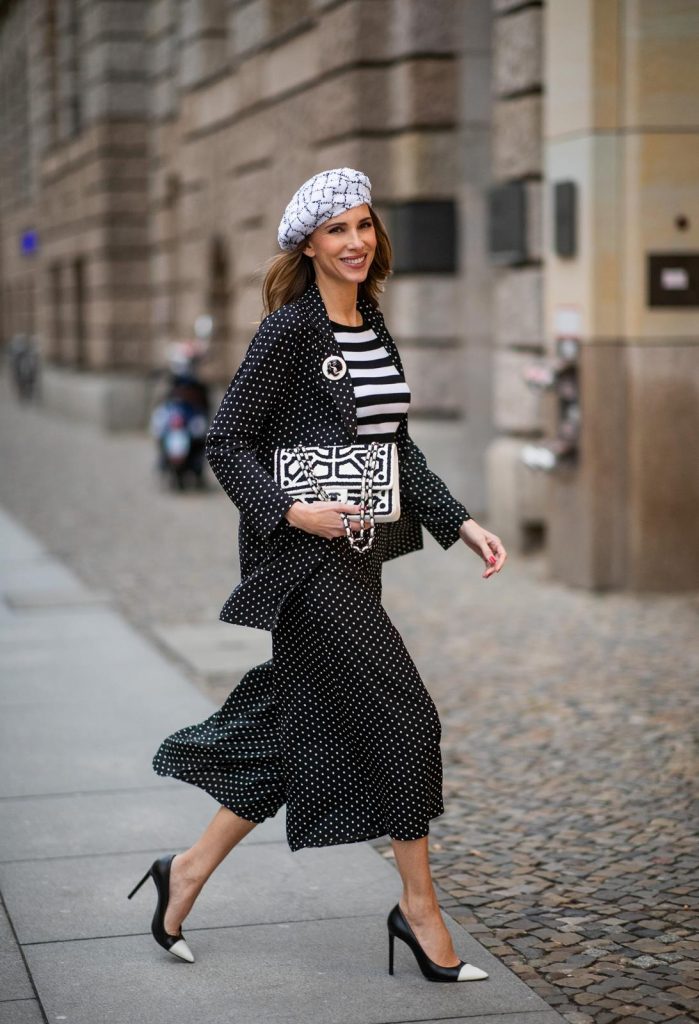 Chanel, Steffen Schraut, Manolo Blahnik Alexandra Lapp in a tweed beret dot suit look, wearing a long black blazer with dots and matching culotte pants, black and white striped sweater with a yellow detail from Steffen Schraut, a black and white tweed beret from the Chanel La Pausa collection, a black and white 2.55 flap bag from Chanel during the Berlin Fashion Week Autumn/Winter 2019 on January 16, 2019 in Berlin, Germany. (Photo by Christian Vierig/Getty Images)
