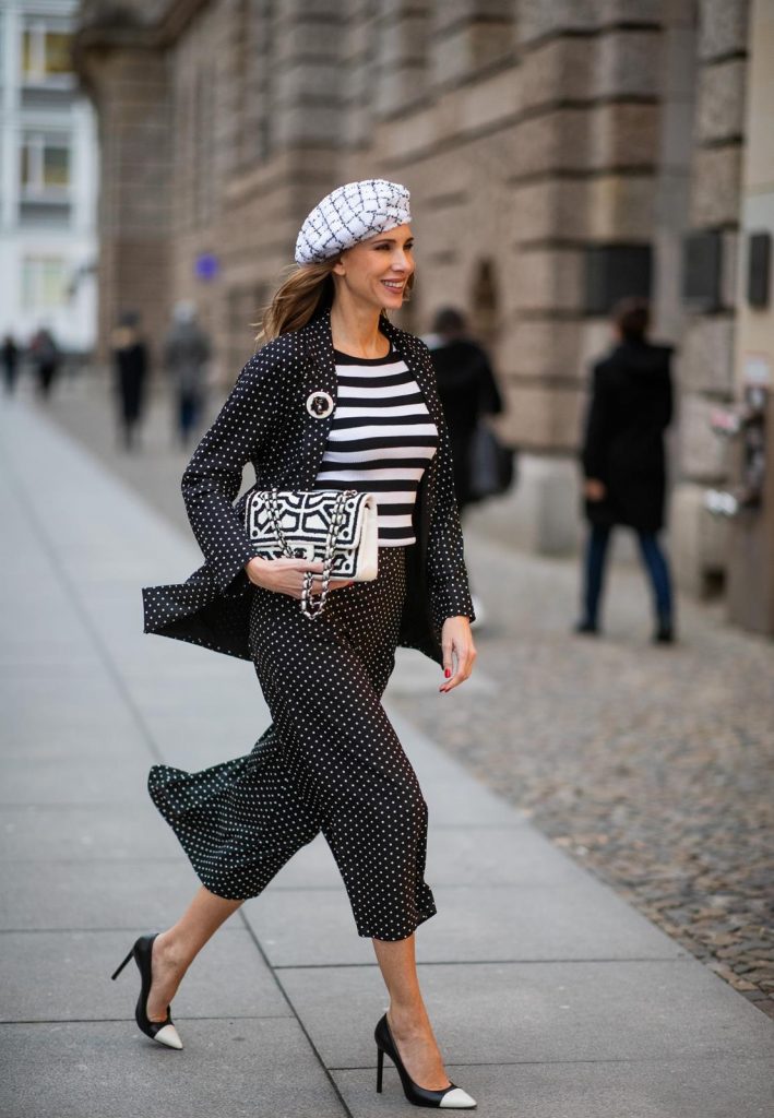 Chanel, Steffen Schraut, Manolo Blahnik Alexandra Lapp in a tweed beret dot suit look, wearing a long black blazer with dots and matching culotte pants, black and white striped sweater with a yellow detail from Steffen Schraut, a black and white tweed beret from the Chanel La Pausa collection, a black and white 2.55 flap bag from Chanel during the Berlin Fashion Week Autumn/Winter 2019 on January 16, 2019 in Berlin, Germany. (Photo by Christian Vierig/Getty Images)