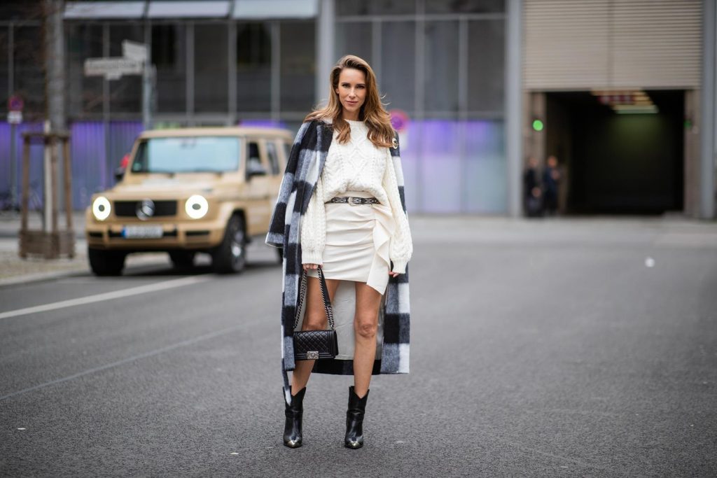 Alexandra Lapp in a Mercedes-Benz Fashion Look, in front of a Mercedes G500 wearing a black and white checked wool-blend coat from Ganni, off-white cable knit sweater from Maje, Isabel Marant ruffled skirt Nefly in off-white, embroided and silver buckled Tety belt and Lamsy ankle cowboy boots with silver tip from Isabel Marant, black Le boy bag from Chanel, Chanel brooch with Coco Chanel detail during the Berlin Fashion Week Autumn/Winter 2019 on January 16, 2019 in Berlin, Germany. (Photo by Christian Vierig/Getty Images)