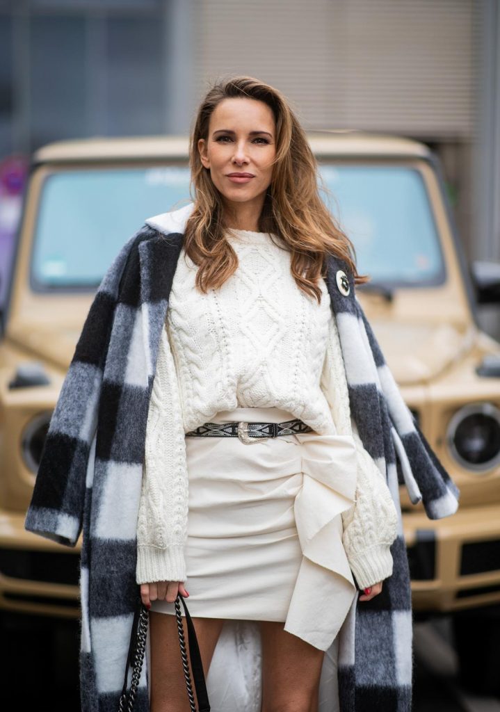 Alexandra Lapp in a Mercedes-Benz Fashion Look, in front of a Mercedes G500 wearing a black and white checked wool-blend coat from Ganni, off-white cable knit sweater from Maje, Isabel Marant ruffled skirt Nefly in off-white, embroided and silver buckled Tety belt and Lamsy ankle cowboy boots with silver tip from Isabel Marant, black Le boy bag from Chanel, Chanel brooch with Coco Chanel detail during the Berlin Fashion Week Autumn/Winter 2019 on January 16, 2019 in Berlin, Germany. (Photo by Christian Vierig/Getty Images)