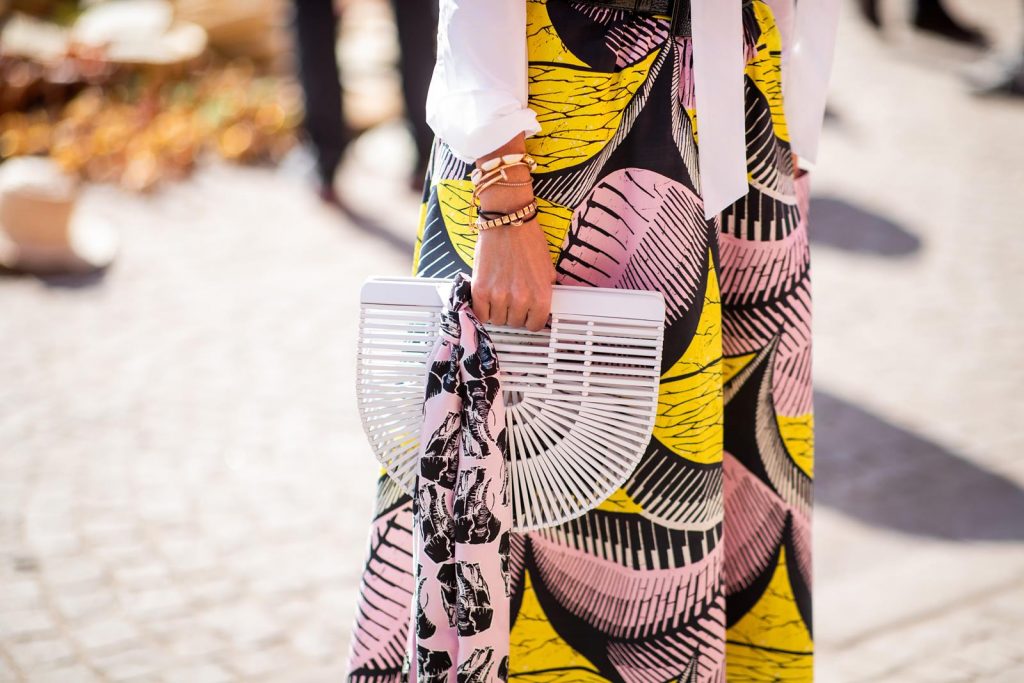 Alexandra Lapp in a Le Riad look, wearing a flared skirt printed with pink, yellow and black patterns combined with a plain bowed white shirt, a matching silk printed scarf with elephants in the same colours and round big earrings in black all by Marc Cain, leather sandals in white, white bag and black cat-eyed shaped sunglasses on November 25, 2018 in Marrakech, Morocco. (Photo by Christian Vierig/Getty Images)