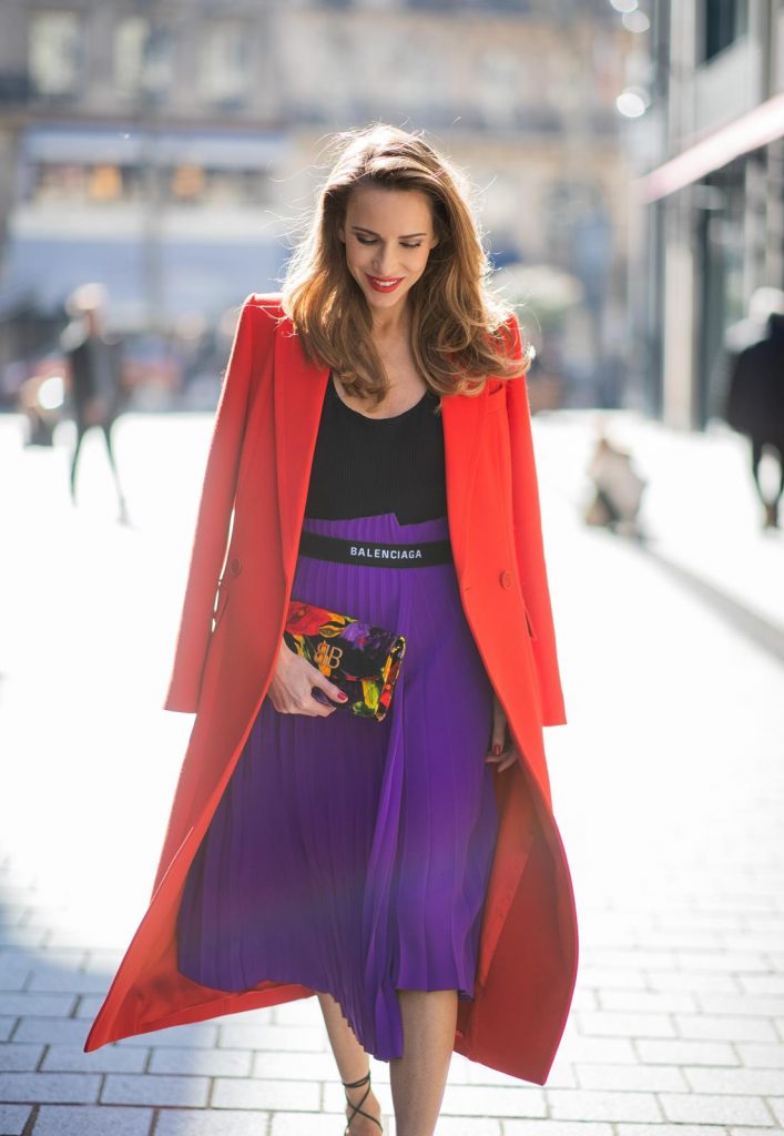 Alexandra Lapp in a Color Flash look, wearing a red Givenchy long coat, a purple Balenciaga plissée skirt, Off-white stretch top, pointed Gianvito Rossi sandals in black, Balenciaga BB printed velvet clutch all from Breuninger during Paris Fashion Week Womenswear Fall/Winter 2019/2020 on February 26, 2019 in Paris, France. (Photo by Christian Vierig/Getty Images)