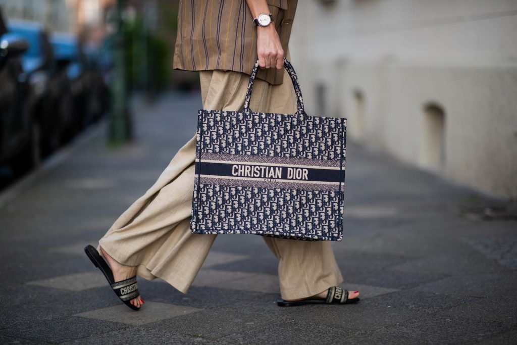 Alexandra Lapp in a Dior Book Tote Bag Look, wearing a beige brown long striped blazer from Zara, white tank top from H&M, waisted belt from Max Mara, high waisted wide leg pants from Staud, Dior Dway mules, Dior Book Tote Dior Oblique bag and a Dior foulard on a blue Borsalino hat on May 04, 2019 in Duesseldorf, Germany. (Photo by Christian Vierig/Getty Images)