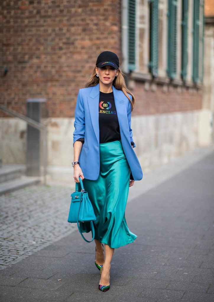 Alexandra Lapp is seen wearing a long turquoise satin skirt from Zara, a black logo print t-shirt from Balenciaga, blue oversized blazer from Zara, black base cap with logo print in rainbow colors from Balenciaga and a turquoise Hermès Kelly bag. on May 04, 2019 in Duesseldorf, Germany. (Photo by Christian Vierig/Getty Images)