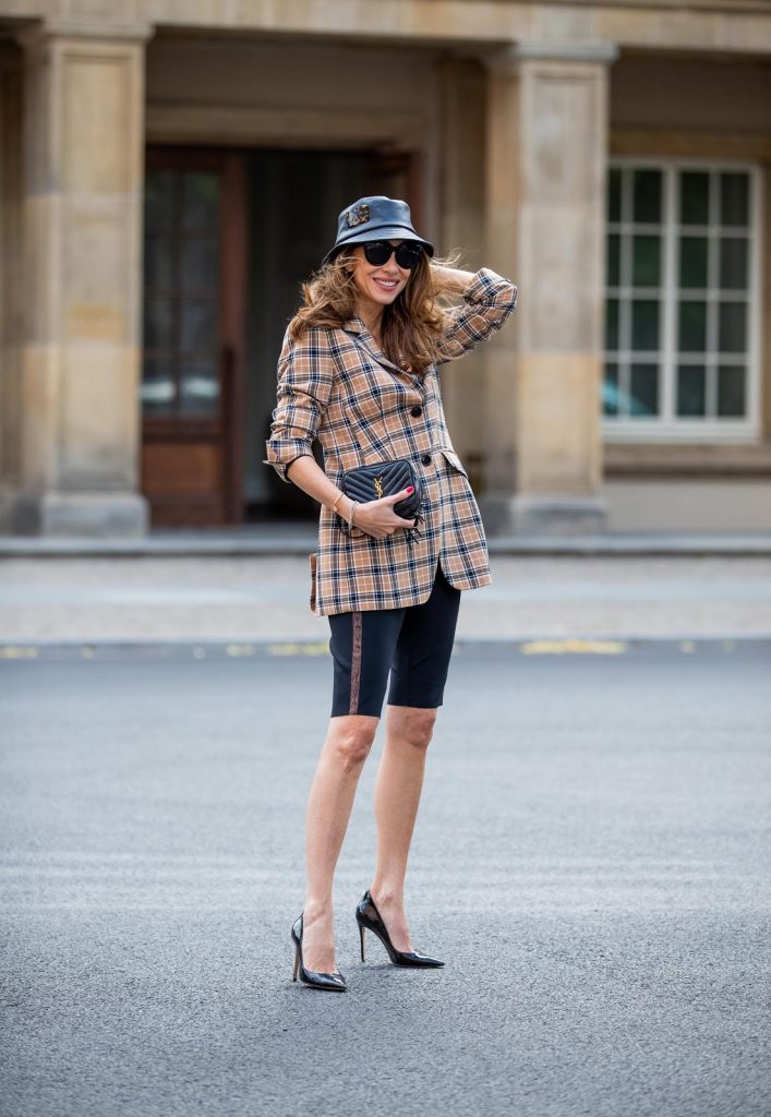 Alexandra Lapp is seen wearing a beige brown checkered blazer, black cycling pants and black bucket hat from Riani, Céline Audrey sunglasses, black St. Laurent Lou belt bag and black Gianvito Rossi patent leather pumps during Berlin Fashion Week on July 02, 2019 in Berlin, Germany. (Photo by Christian Vierig/Getty Images)