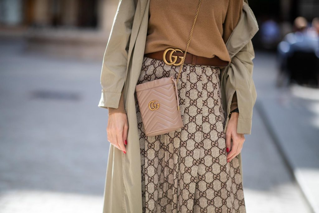 PARIS, FRANCE - SEPTEMBER 23:Blogger, Model and Influencer Alexandra Lapp is seen wearing a Gucci GG pleated jersey midi skirt, GG Marmont Mini-Bucket bag in nude, Christian Louboutin So Kate pumps in camel, camel Nili Lotan sweater, beige Zara trenchcoat during Paris Fashion Week Womenswear Spring Summer 2020 on September 23, 2019 in Paris, France. 