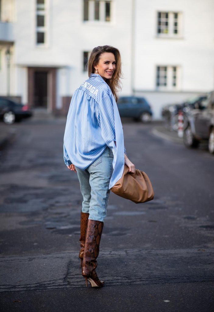 DUESSELDORF, GERMANY - DECEMBER 10: Alexandra Lapp is seen wearing brown Zara teddy coat, oversized blue striped button shirt Balenciaga, brown Gucci belt, light blue ripped denim jeans Celine, brown Pouch bag Bottega Veneta, brown Jimmy Choo boots with snake print on December 10, 2019 in Duesseldorf, Germany. 