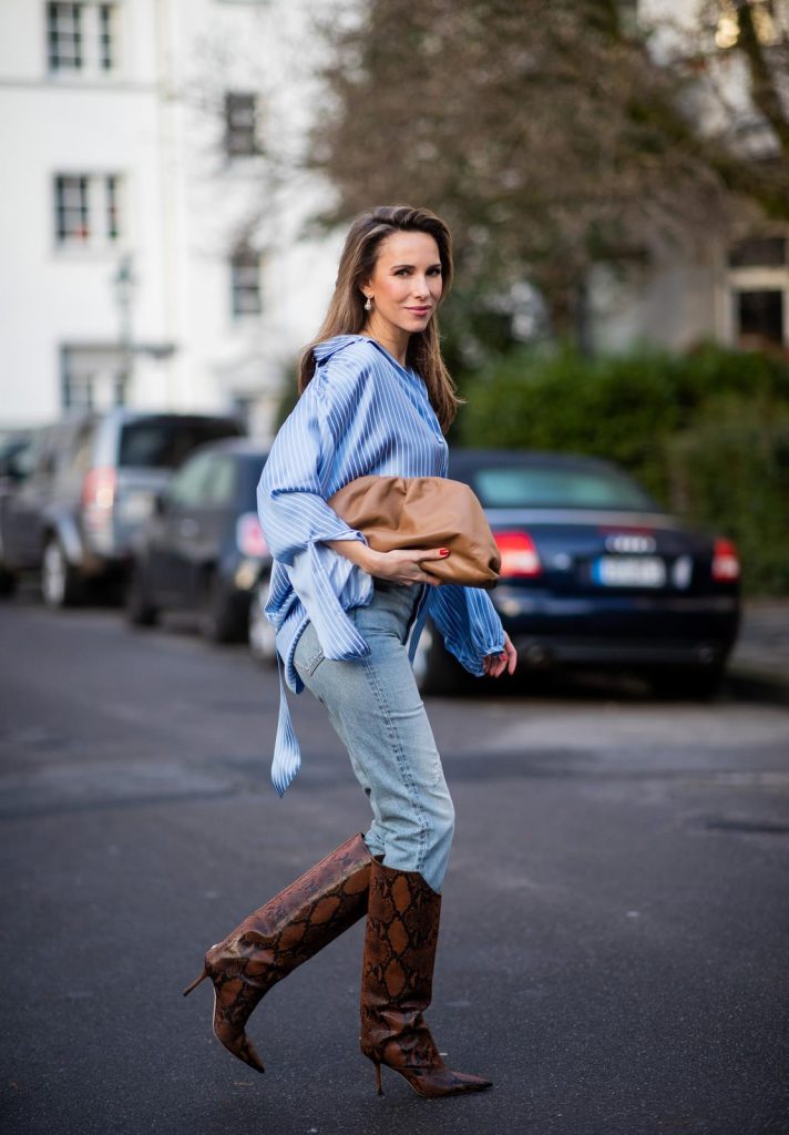 DUESSELDORF, GERMANY - DECEMBER 10: Alexandra Lapp is seen wearing brown Zara teddy coat, oversized blue striped button shirt Balenciaga, brown Gucci belt, light blue ripped denim jeans Celine, brown Pouch bag Bottega Veneta, brown Jimmy Choo boots with snake print on December 10, 2019 in Duesseldorf, Germany. 