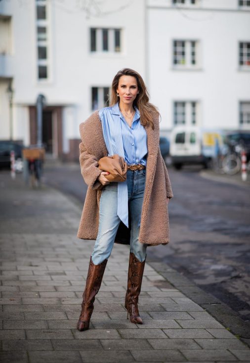 DUESSELDORF, GERMANY - DECEMBER 10: Alexandra Lapp is seen wearing brown Zara teddy coat, oversized blue striped button shirt Balenciaga, brown Gucci belt, light blue ripped denim jeans Celine, brown Pouch bag Bottega Veneta, brown Jimmy Choo boots with snake print on December 10, 2019 in Duesseldorf, Germany.