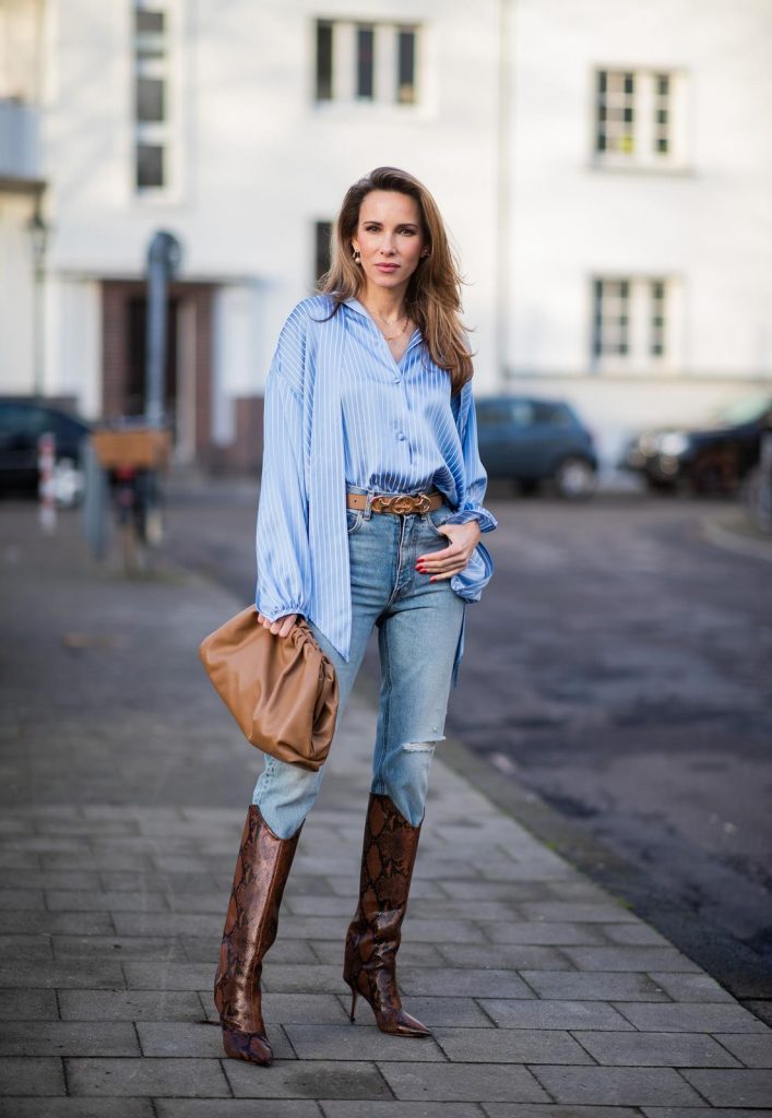 DUESSELDORF, GERMANY - DECEMBER 10: Alexandra Lapp is seen wearing brown Zara teddy coat, oversized blue striped button shirt Balenciaga, brown Gucci belt, light blue ripped denim jeans Celine, brown Pouch bag Bottega Veneta, brown Jimmy Choo boots with snake print on December 10, 2019 in Duesseldorf, Germany. 