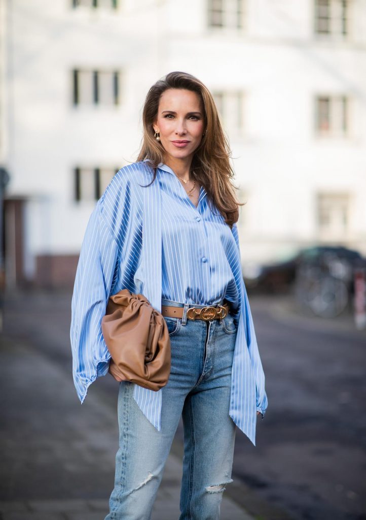 DUESSELDORF, GERMANY - DECEMBER 10: Alexandra Lapp is seen wearing brown Zara teddy coat, oversized blue striped button shirt Balenciaga, brown Gucci belt, light blue ripped denim jeans Celine, brown Pouch bag Bottega Veneta, brown Jimmy Choo boots with snake print on December 10, 2019 in Duesseldorf, Germany. 