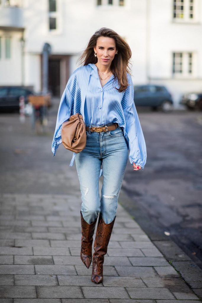 DUESSELDORF, GERMANY - DECEMBER 10: Alexandra Lapp is seen wearing brown Zara teddy coat, oversized blue striped button shirt Balenciaga, brown Gucci belt, light blue ripped denim jeans Celine, brown Pouch bag Bottega Veneta, brown Jimmy Choo boots with snake print on December 10, 2019 in Duesseldorf, Germany. 