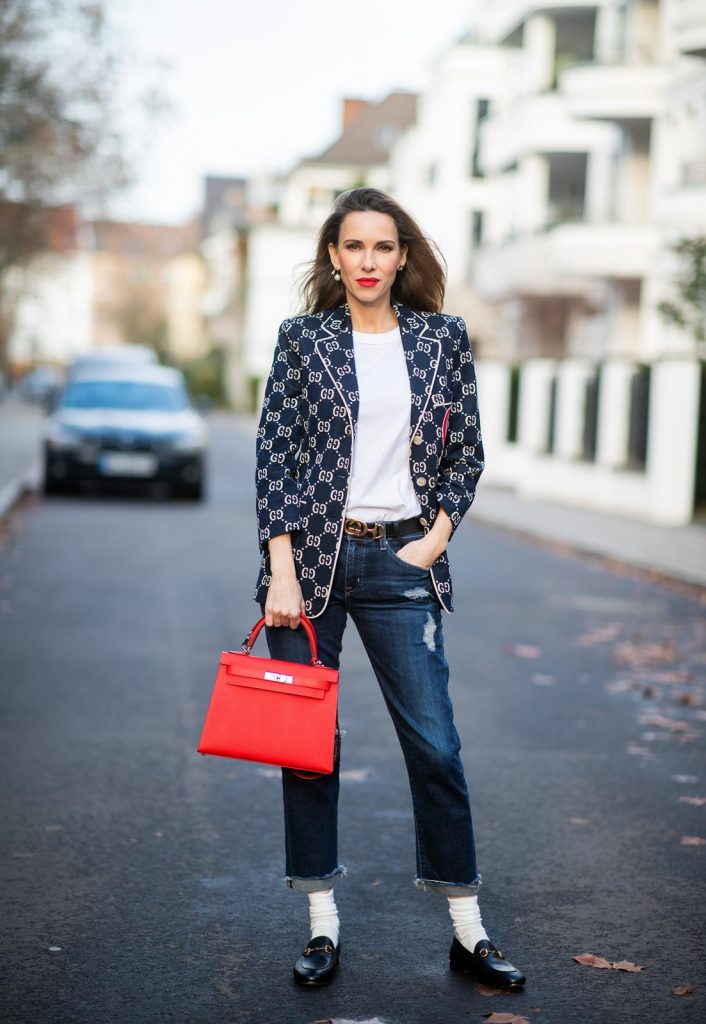 college look, Gucci, AG Denim, Adriano Goldschmied, Gucci loafers, Falke, Dior, The Frankie Shop, Hermes, Kelly bag DUESSELDORF, GERMANY - DECEMBER 11: Alexandra Lapp is seen wearing a college look, dark denim blue jeans AG Jeans, white sleeveless muscle tshirt with padded shoulders The Frankie Shop, Gucci GG horsebit leather belt, Gucci college jacket with logo print, red Hermes Kelly bag on December 11, 2019 in Duesseldorf, Germany. (Photo by Christian Vierig/Getty Images)
