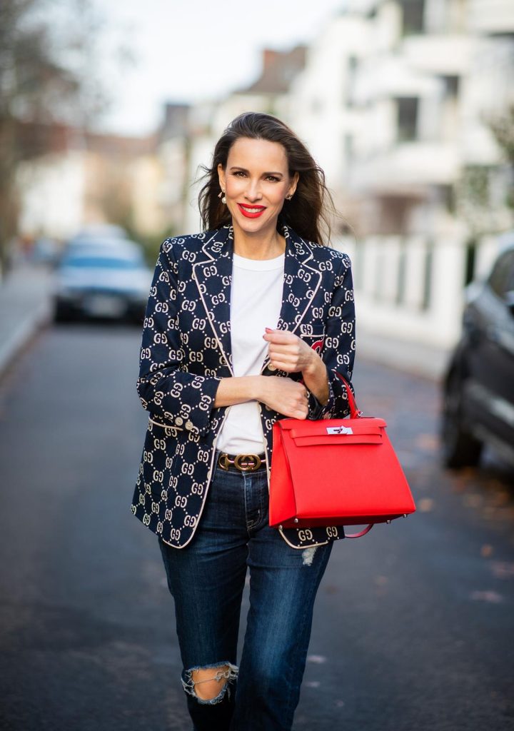 college look, Gucci, AG Denim, Adriano Goldschmied, Gucci loafers, Falke, Dior, The Frankie Shop, Hermes, Kelly bag DUESSELDORF, GERMANY - DECEMBER 11: Alexandra Lapp is seen wearing a college look, dark denim blue jeans AG Jeans, white sleeveless muscle tshirt with padded shoulders The Frankie Shop, Gucci GG horsebit leather belt, Gucci college jacket with logo print, red Hermes Kelly bag on December 11, 2019 in Duesseldorf, Germany. (Photo by Christian Vierig/Getty Images)
